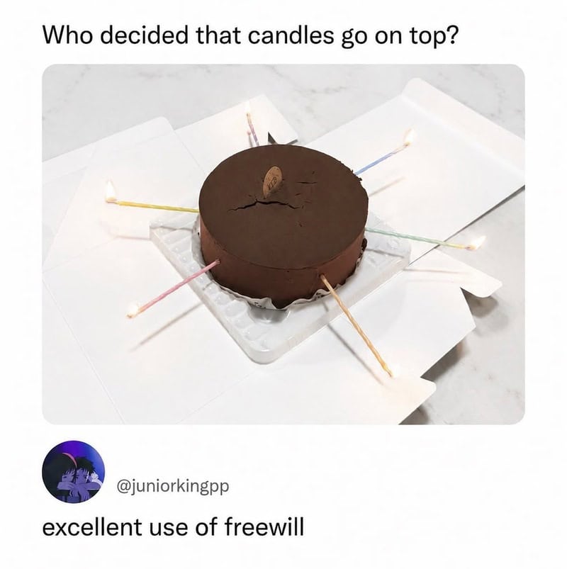 Chocolate cake with candles, some knocked over, on a white box with text about candles.