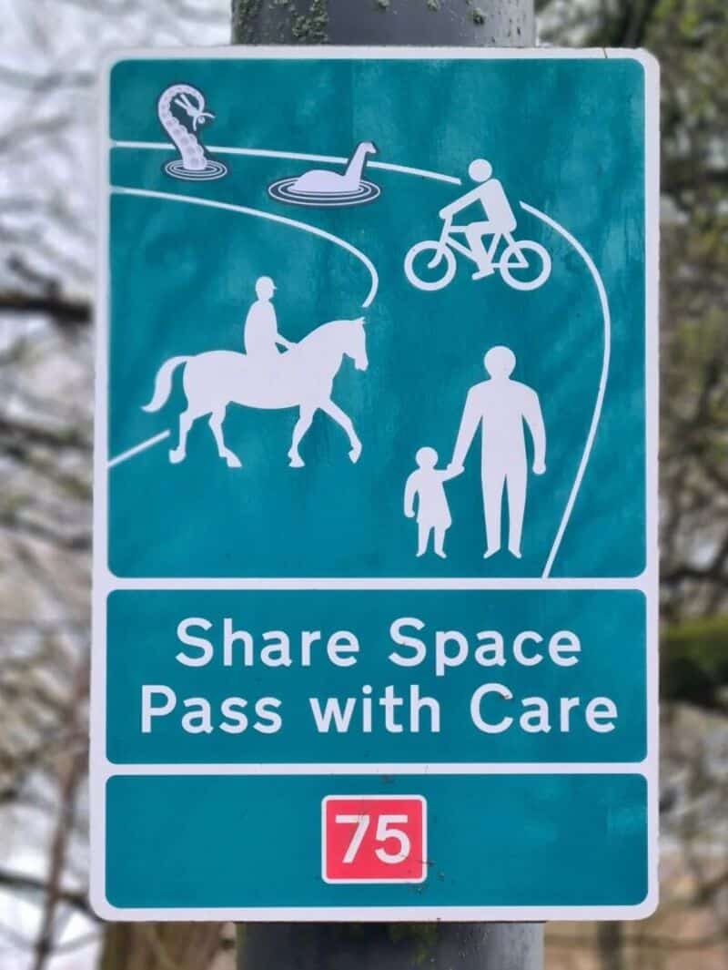 Share Space Pass with Care sign with water, bike, horse, and person icons.