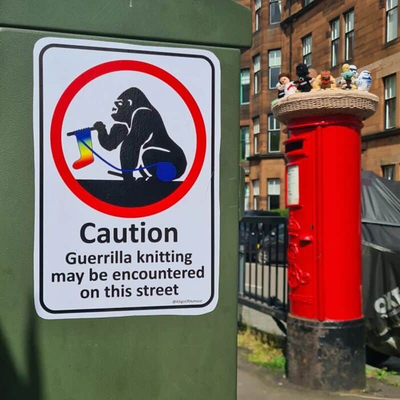 Caution sign warns of guerrilla knitting on this street with a gorilla knitting.