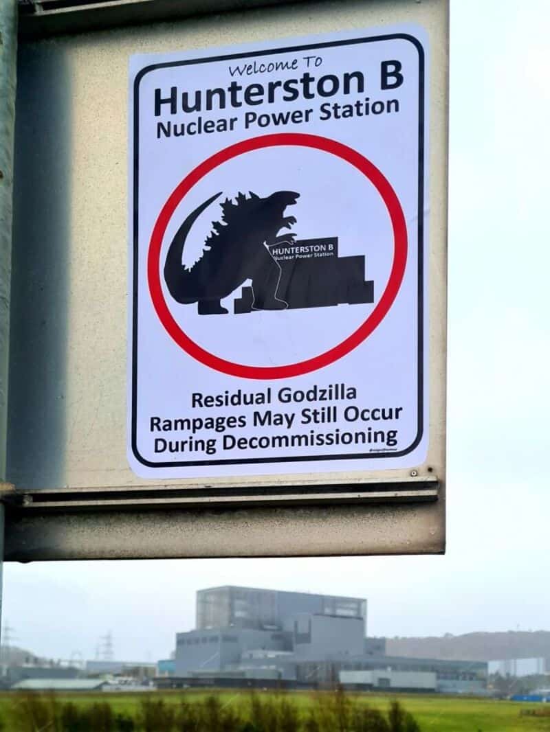 Sign at Hunterston B Nuclear Power Station with Godzilla illustration and humorous warning.
