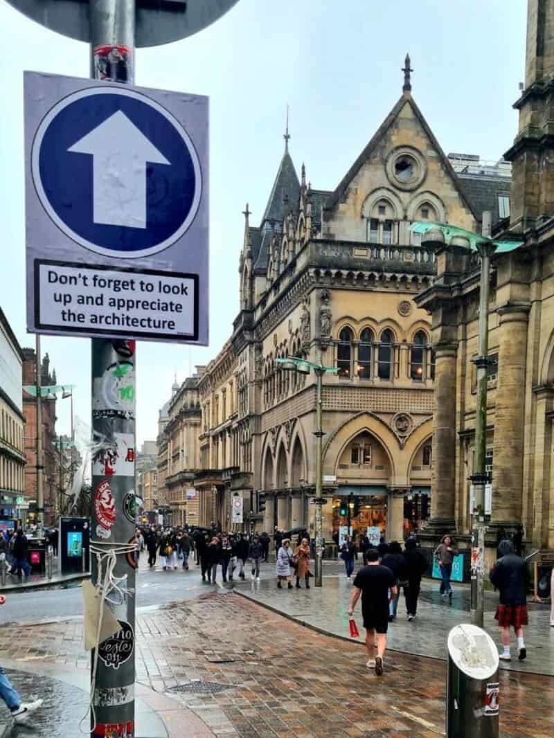 One-way street sign with a humorous message about architecture appreciation.