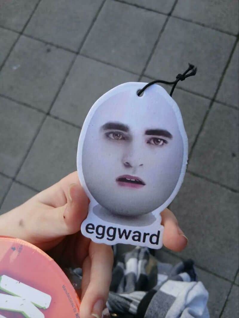 Hand holding a paper cutout of a face with the word 'eggward' below.