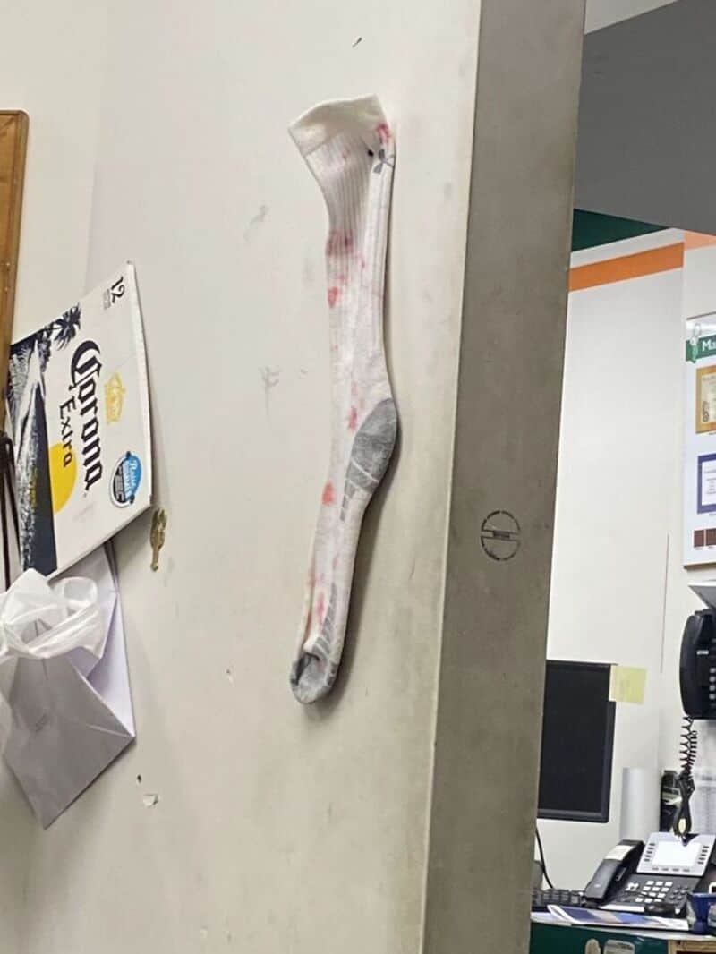 A blood-stained sock hanging on a wall in a convenience store.
