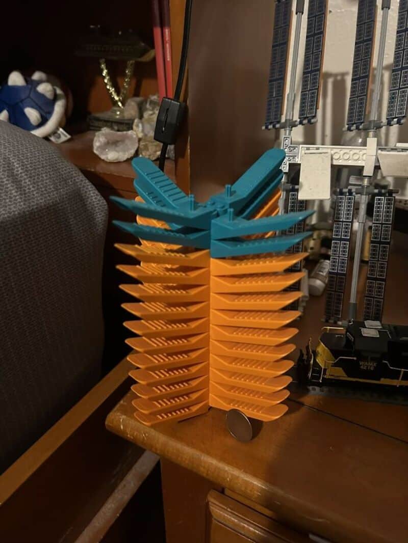 Stacked orange and blue plastic objects resembling a tall, abstract sculpture.
