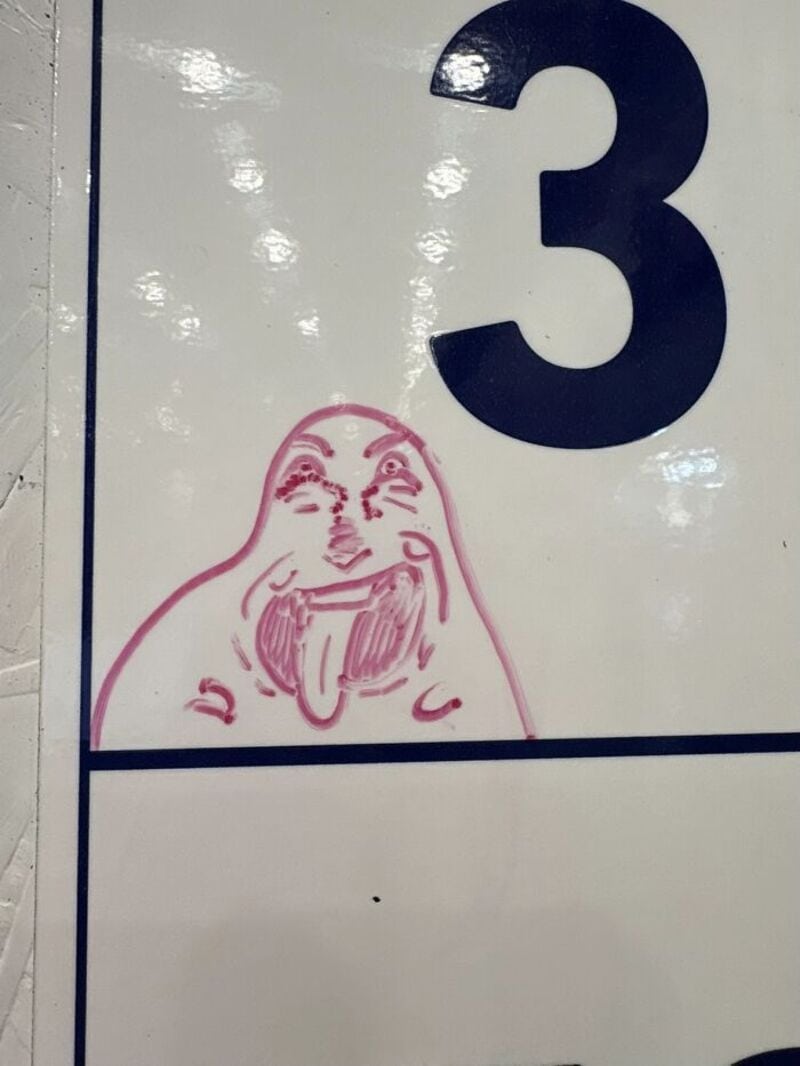 Number 3 with a pink doodle of a face sticking out its tongue.