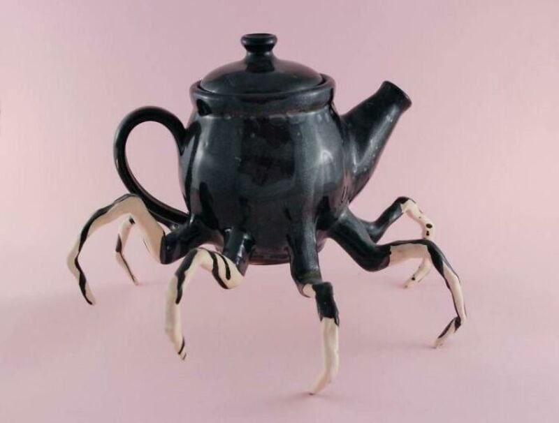 Teapot with crab legs attached, resembling a crab with a teapot body.