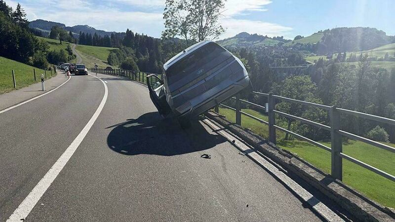 Car crashed into guardrail on a winding road in a rural area.