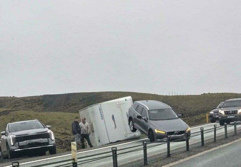 Car crashed into a van on the side of the road, with other cars nearby.