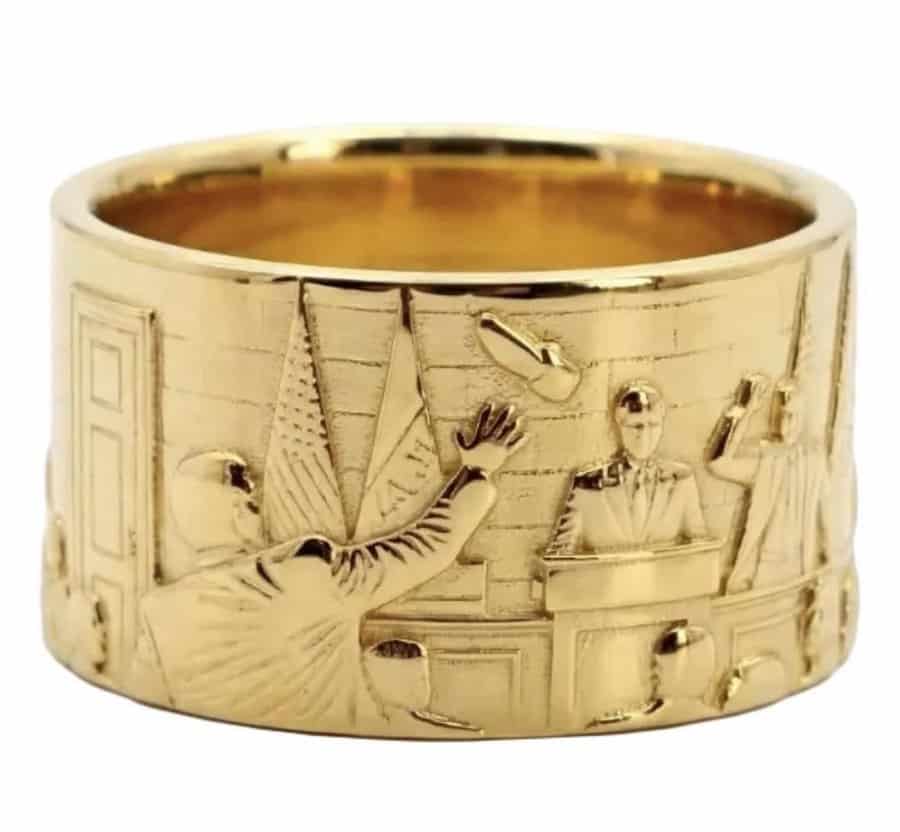 Gold ring with detailed courtroom scene relief, including judge, lawyer, and witness.