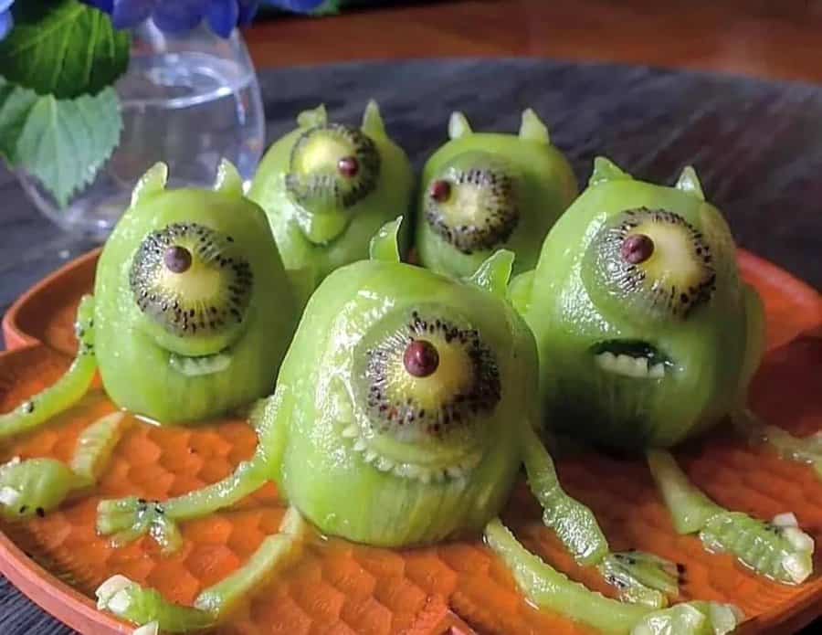 Creative kiwi fruit sculptures with eyes and limbs, resembling small monsters.