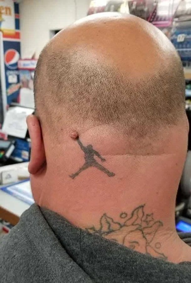 Bald man with a tattoo of a jumping basketball player on the back of his head.