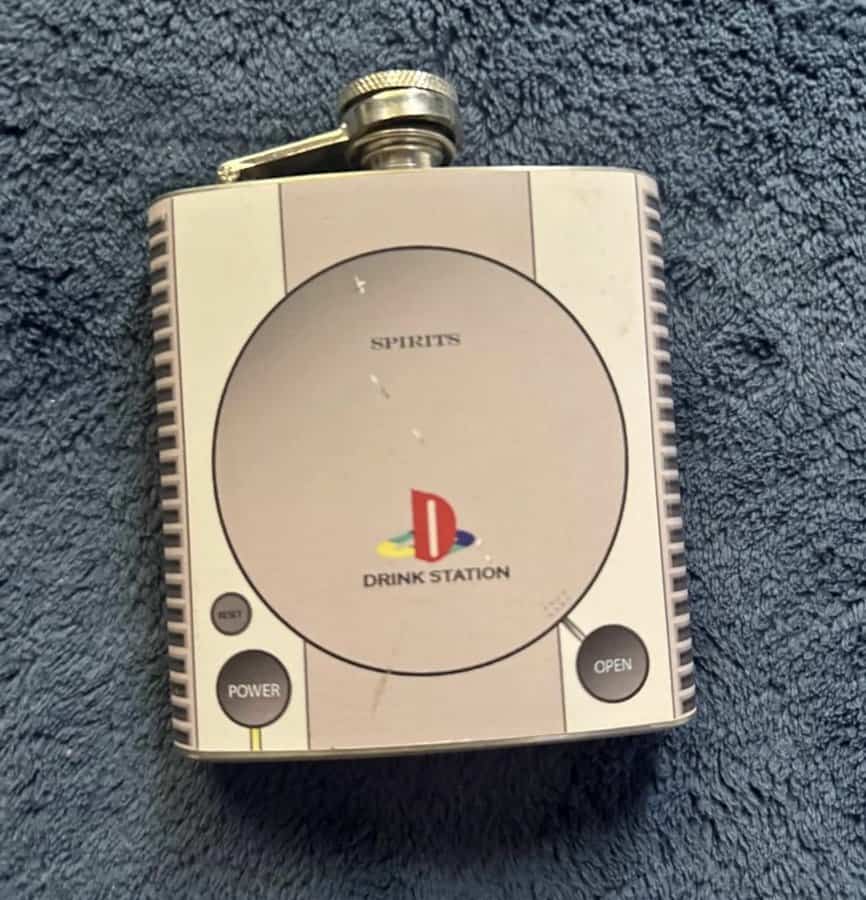 A flask designed to look like a vintage gaming console with 'Drink Station' label.