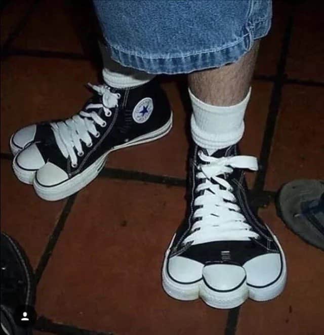 Person wearing Converse sneakers with a unique design resembling a cartoon character.