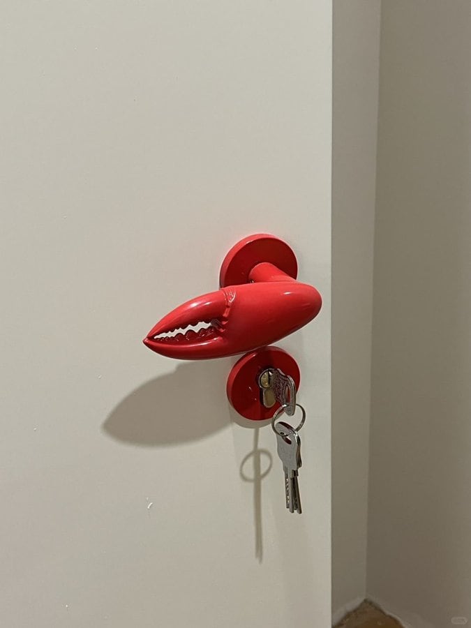 Door handle with lips-shaped design and a key in the lock.