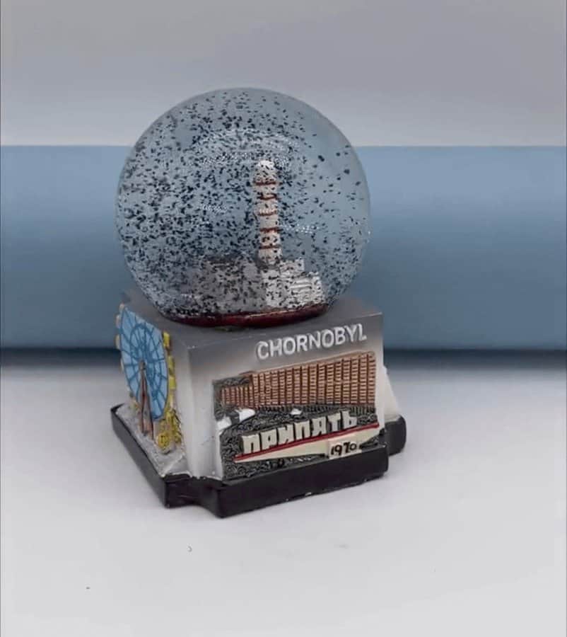 Snow globe with a lighthouse inside, labeled 'Chornobyl' and '1970s'.