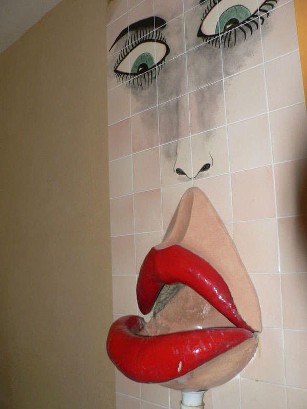 Large face mural with exaggerated lips and eyes, tiled background.