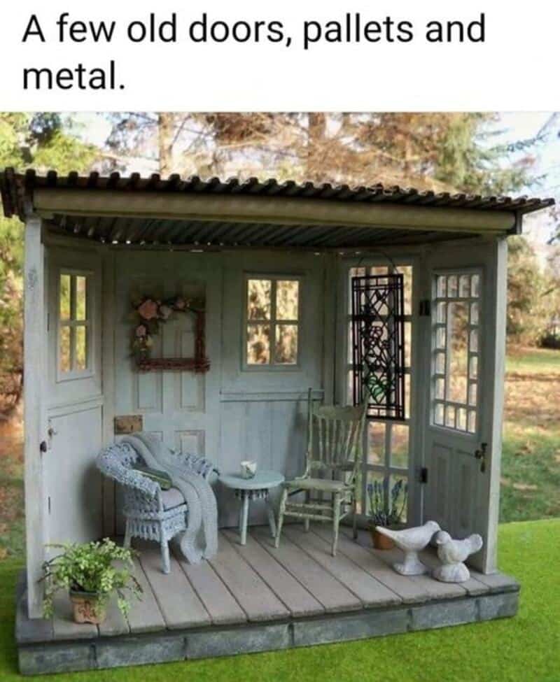 Miniature porch with old doors, pallets, metal, chairs, and decor.