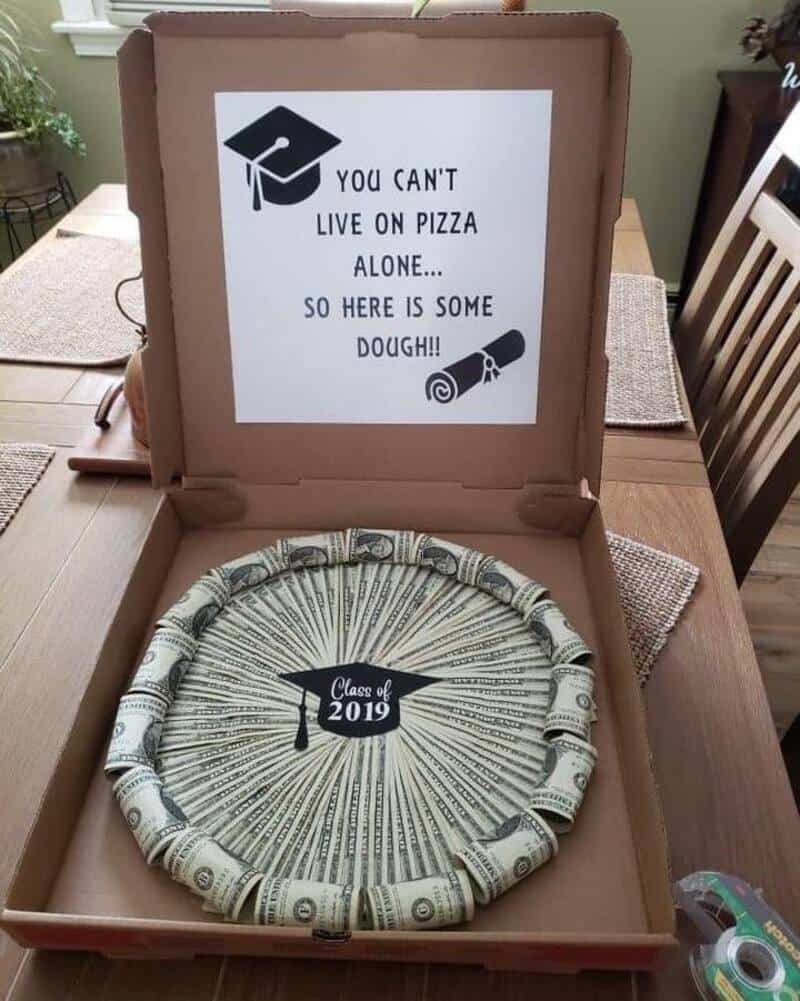 Pizza dough in a box with a humorous note about living on pizza alone.