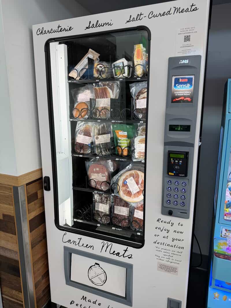 Vending machine labeled 'Canteen Meats' with various packaged meats inside.