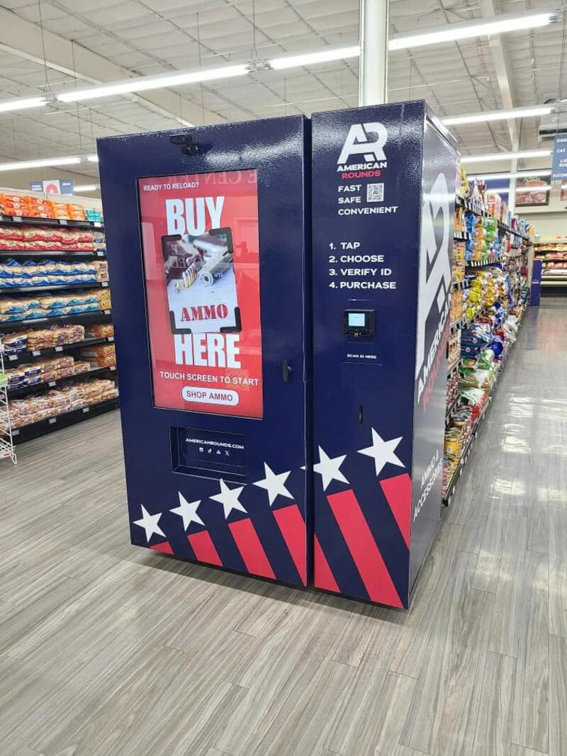 Vending machine with American flag design and buy ammo sign inside a store.