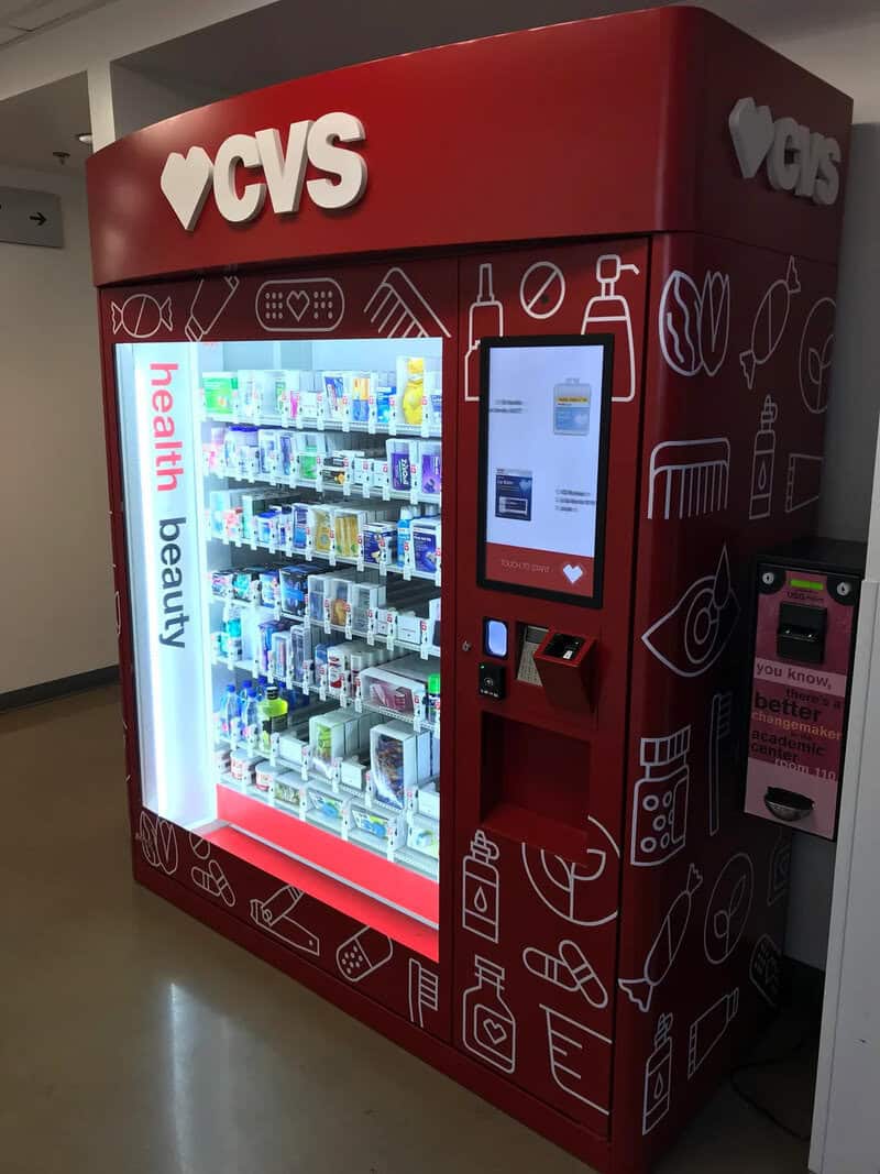 CVS vending machine with health and beauty products, digital payment screen, and colorful display.