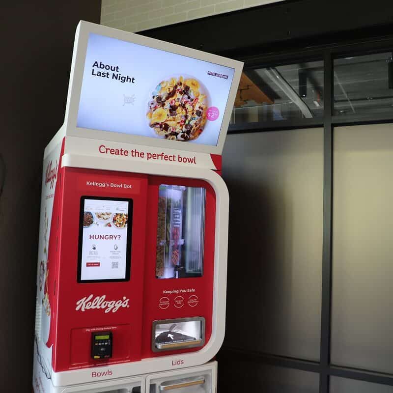 Kellogg's Bowl Bot vending machine with digital screen and snack display.