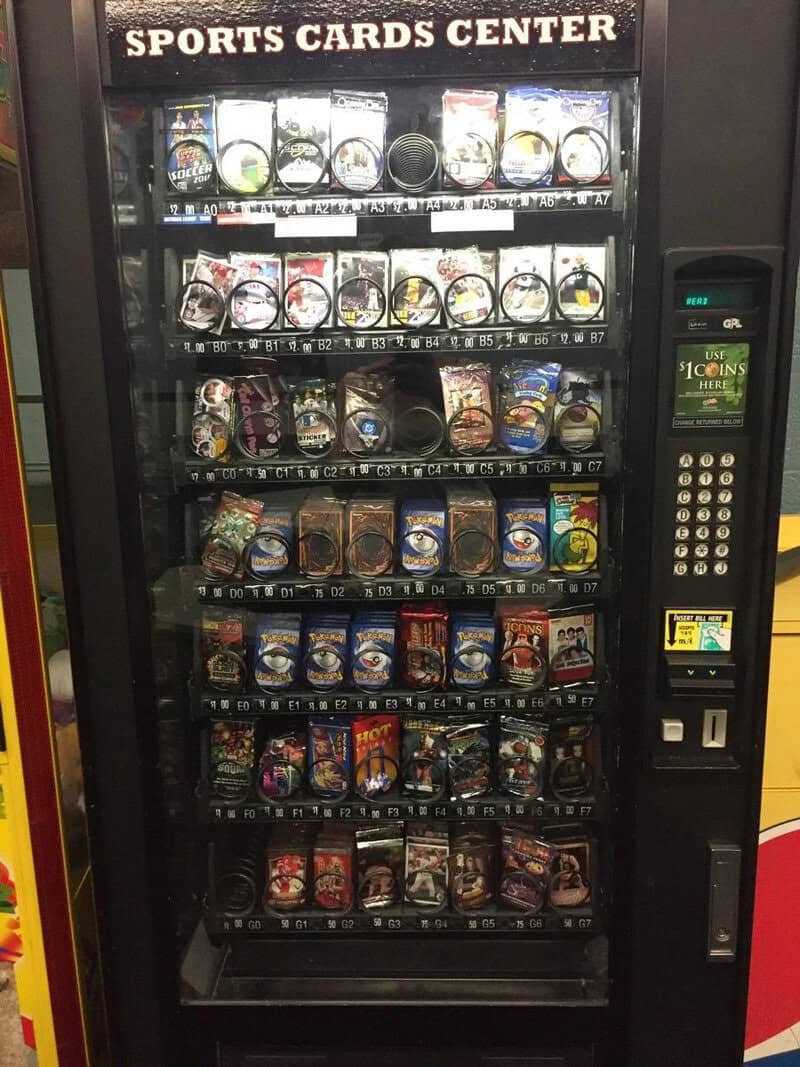 Vending machine labeled 'Sports Cards Center' with various sports card packs inside.