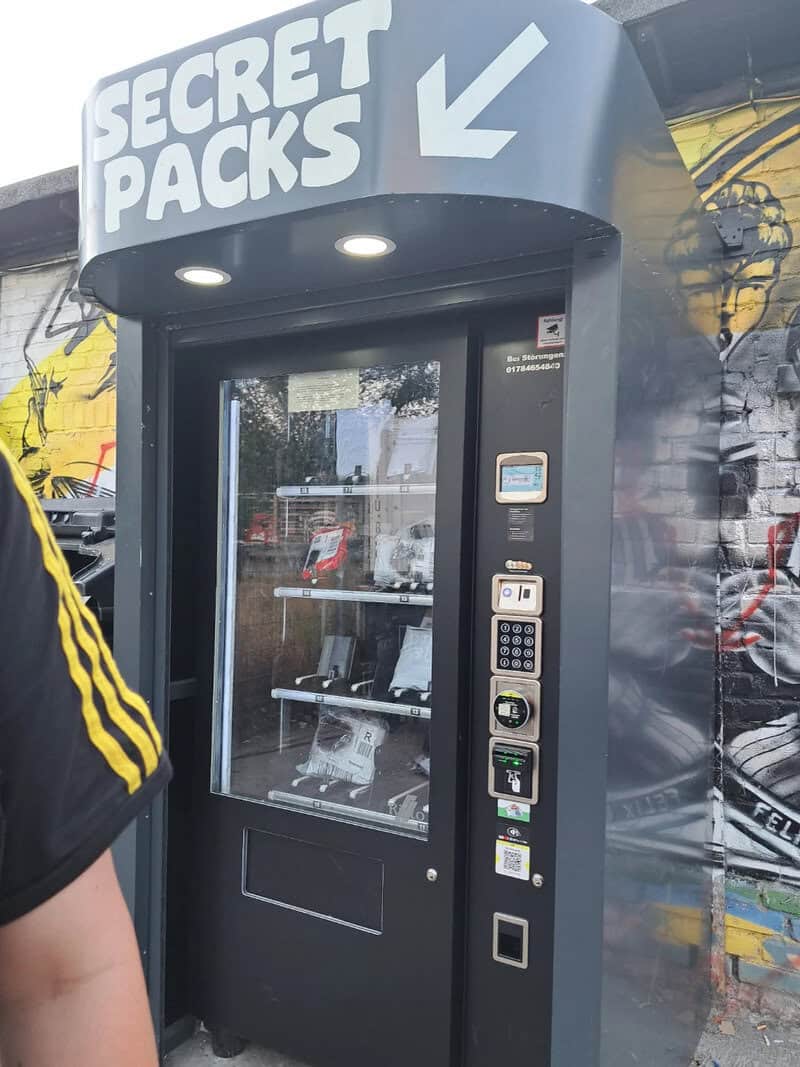 Vending machine labeled 'Secret Packs' with a glass front and payment options.