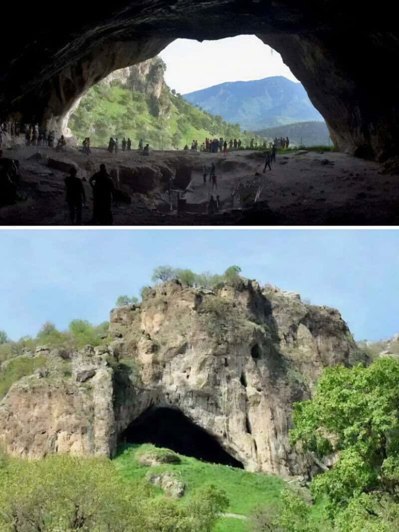 Large cave with people inside and a mountain view in the background.