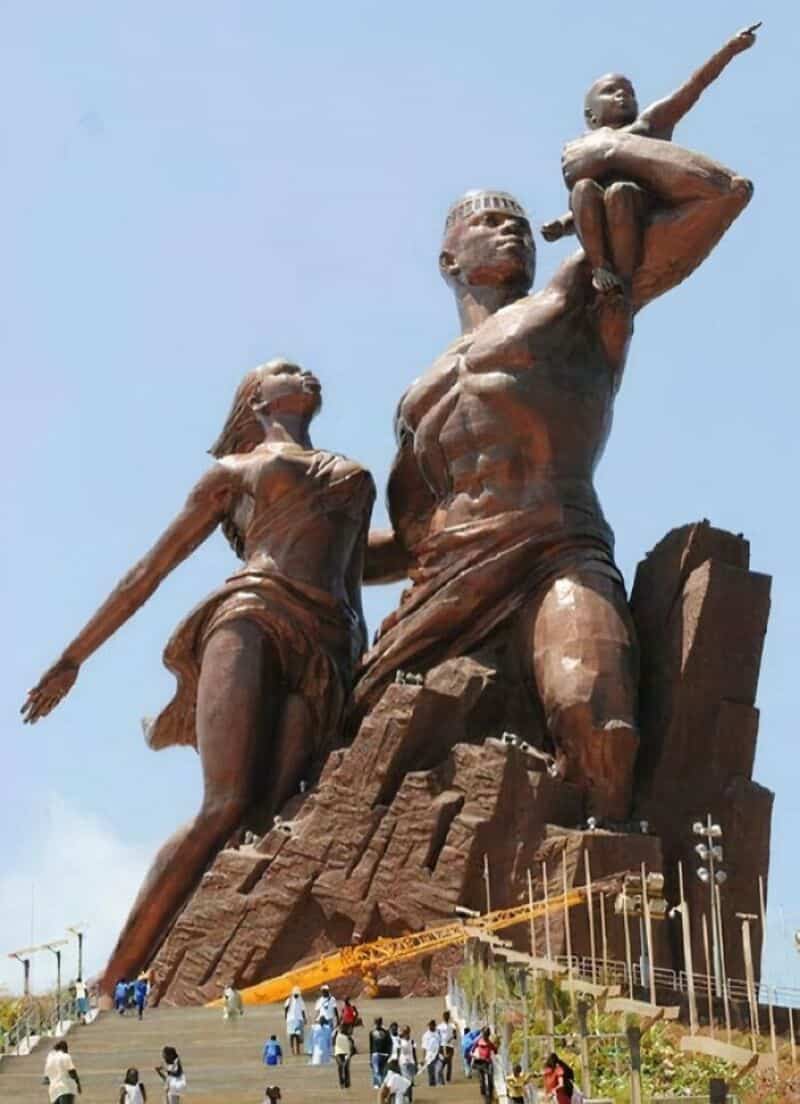 Large monument of a family with a man, woman, and child pointing forward.