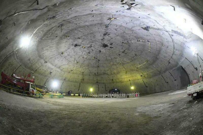 Large underground cavern with construction equipment and lighting.