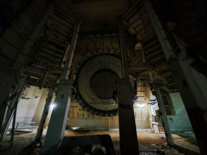 Large industrial machinery with a circular opening, surrounded by metal structures.