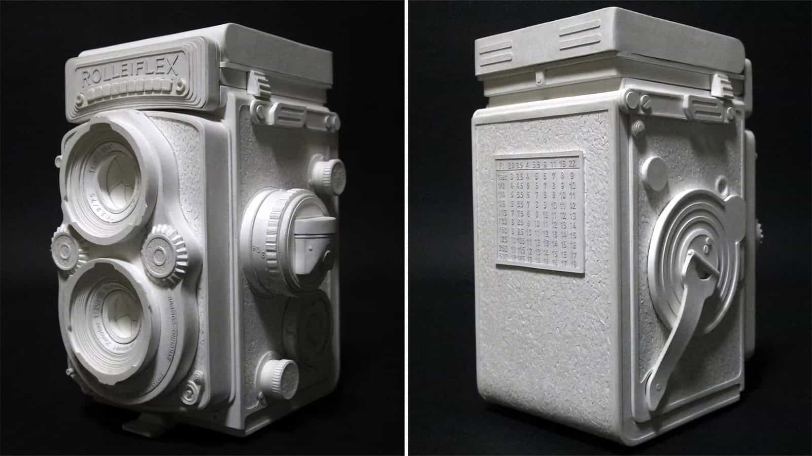 Paper sculpture of a vintage camera with detailed dials and lens.