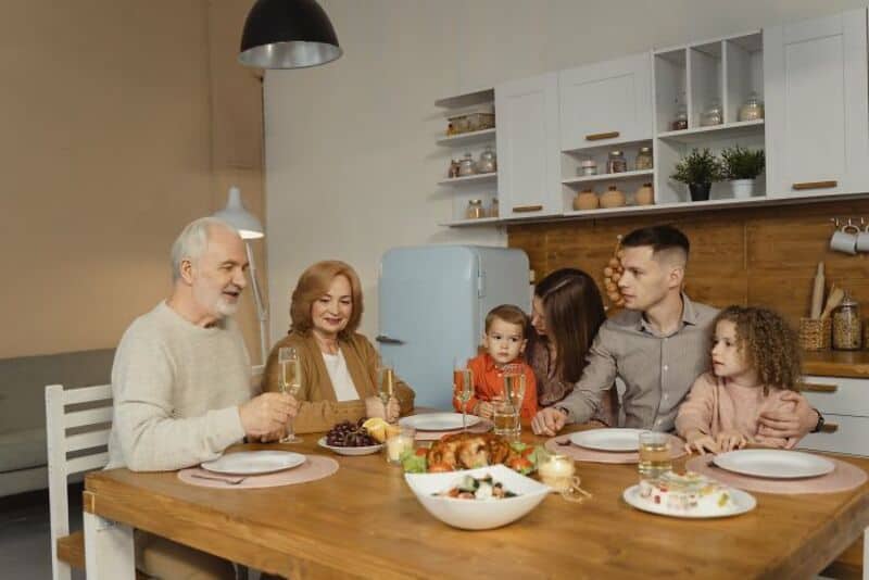 Family celebrating dinner together in a modern kitchen.