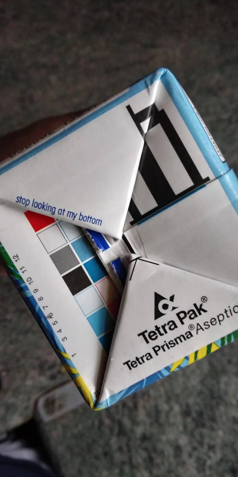 Close-up of a TetraPak carton with a color chart and the text 'stop looking at my bottom'.