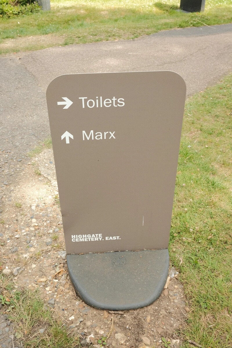 Sign pointing to toilets and Marx at Highgate Cemetery East.