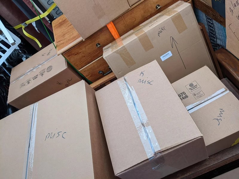 Multiple cardboard boxes labeled 'misc' stacked in a room.