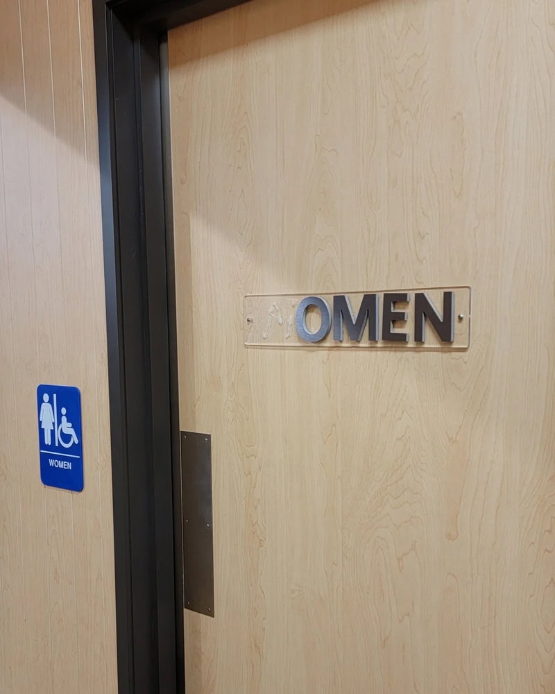 Door with 'OMEN' sign and a women's restroom sign nearby.