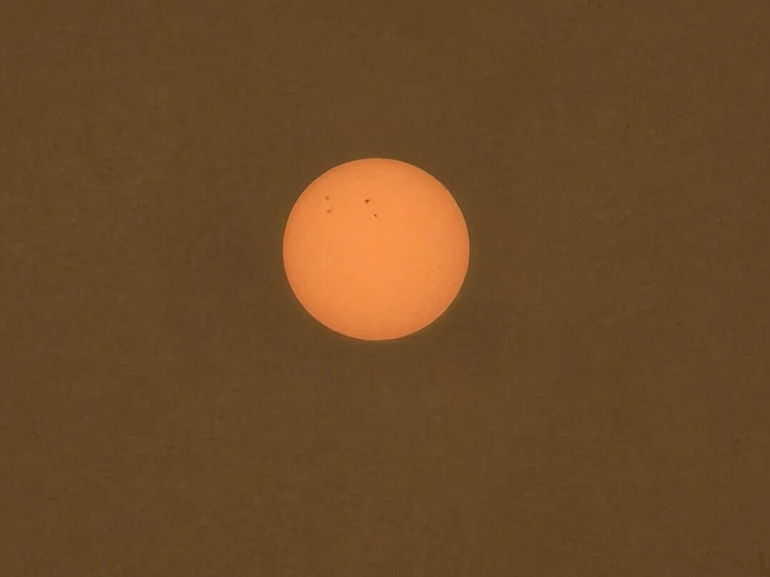 The sun appears as a large orange sphere in a dark sky.