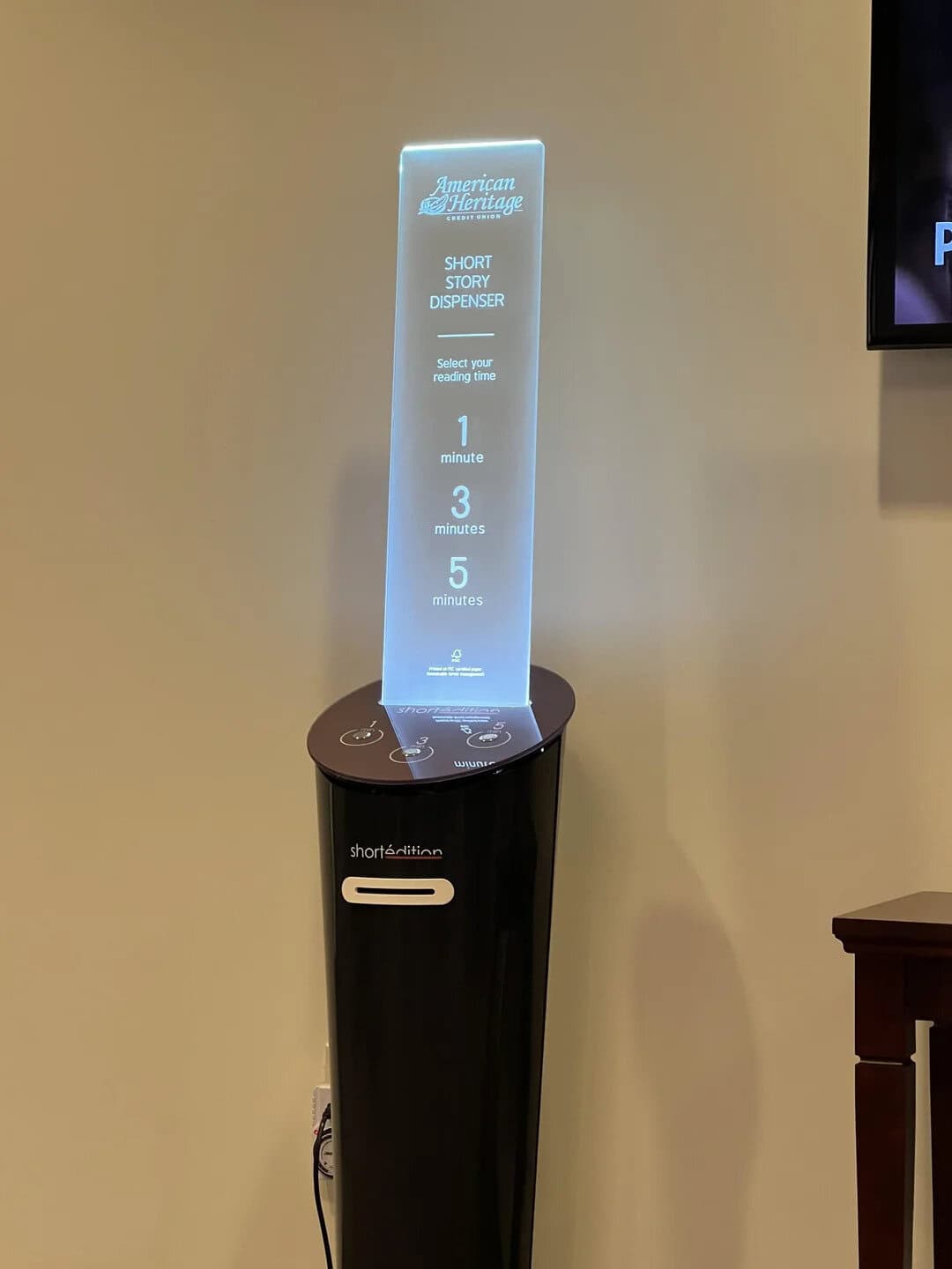 American Heritage short story dispenser with a digital screen showing reading time options.