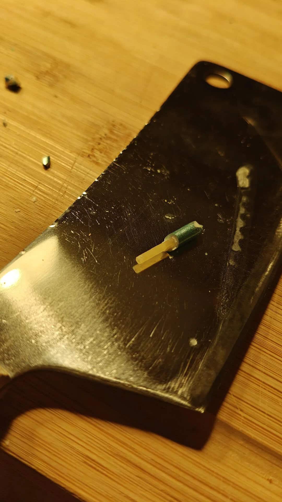 Small electronic component on a black cutting board on a wooden surface.