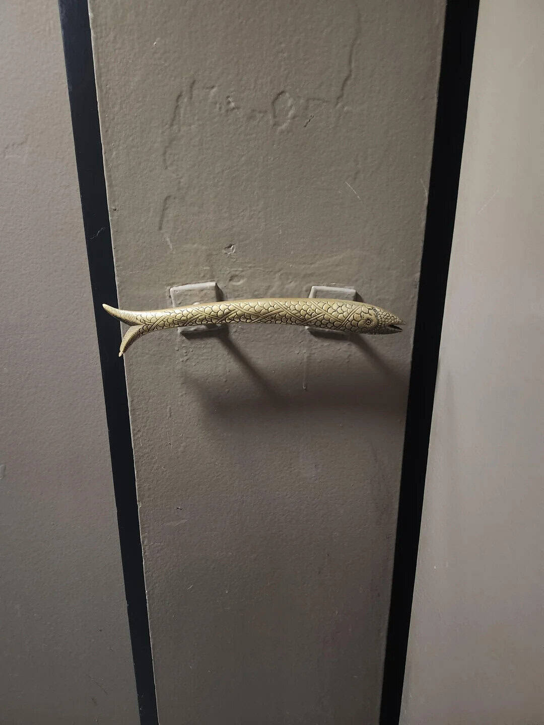 A lizard on a gray wall with black frame, labeled 'mildly interesting'.