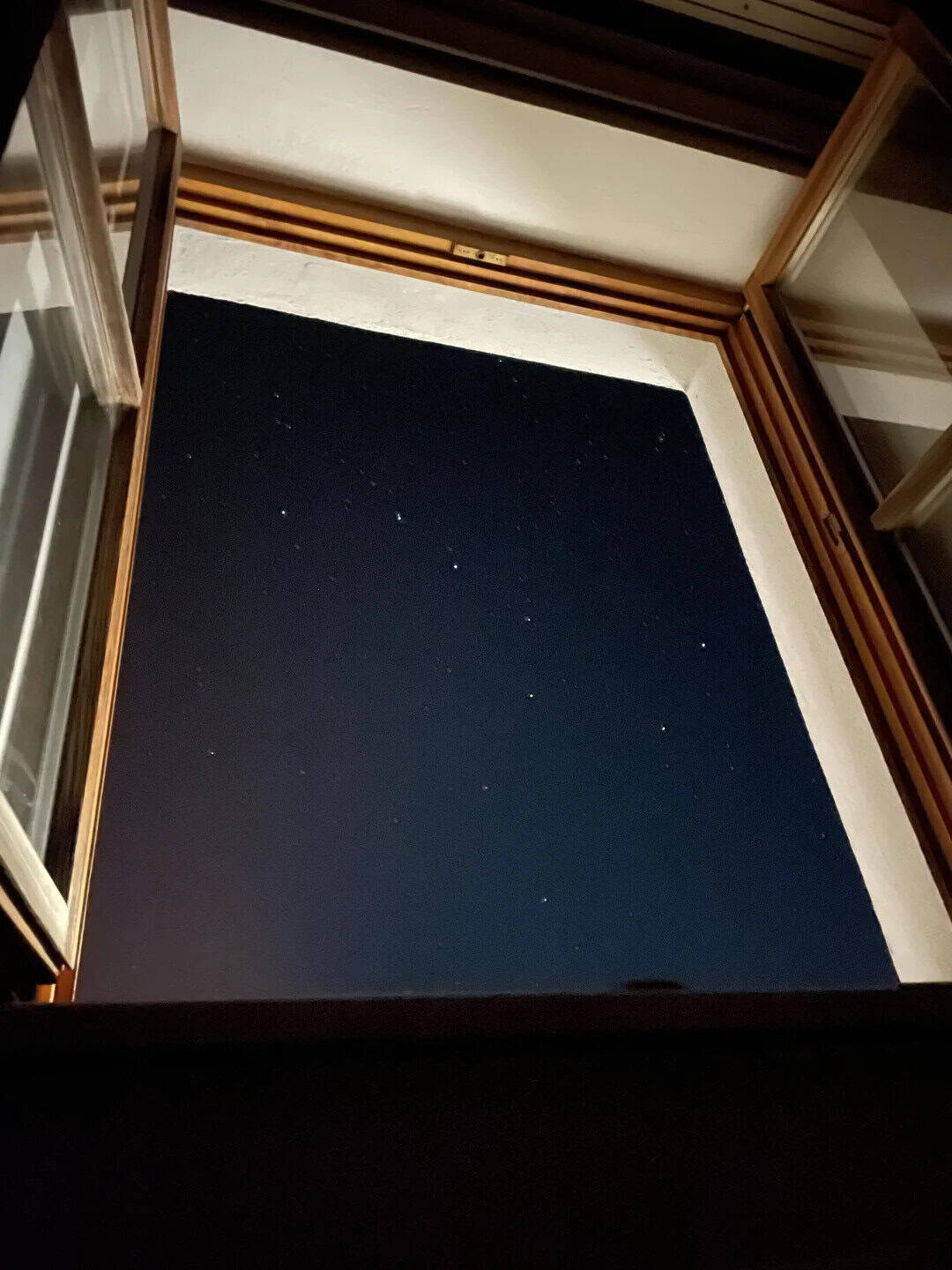 Open window showing a starry night sky.