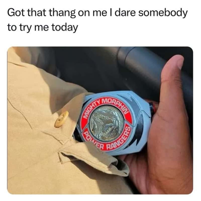 Person holding a Power Rangers Mighty Morphin Power Rangers watch with a dinosaur emblem.