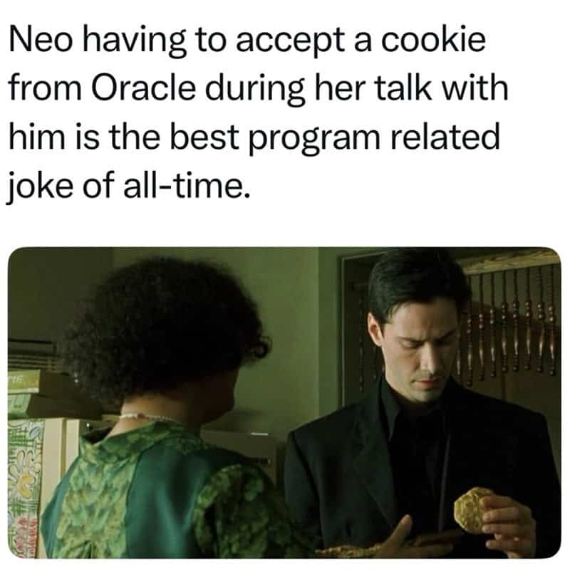Neo accepting a cookie from Oracle during her talk, with a serious expression.