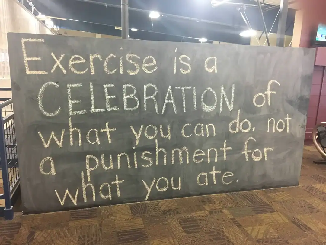 Chalkboard sign with motivational quote about exercise and food.