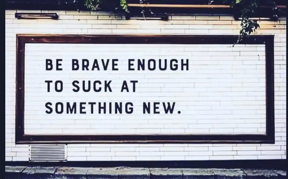 Be brave enough to suck at something new motivational sign.