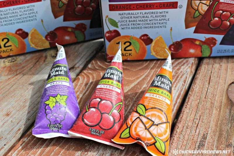 Three Minute Maid juice bars in grape, cherry, and orange flavors on a wooden surface.