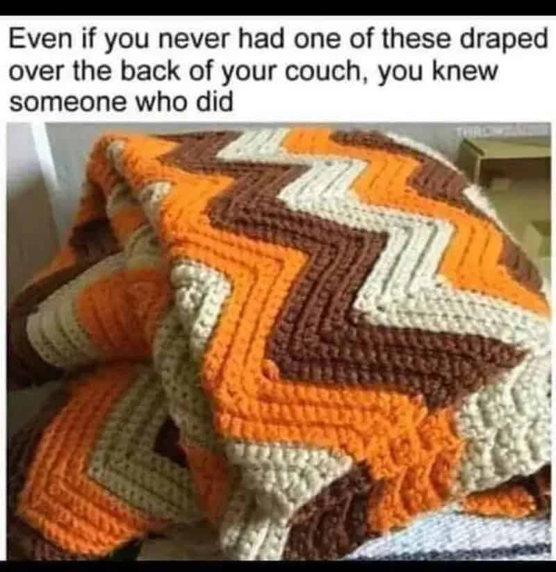 Colorful zigzag crocheted blanket draped over a couch.