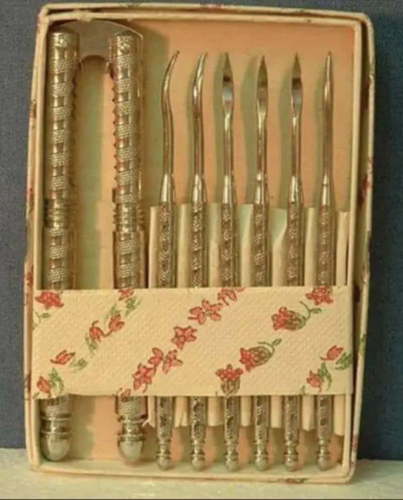 Set of vintage metal dental tools in a floral box.